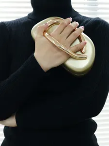 Gold metal handle clutch bag detail view, luxury evening party handbag close up showcase.