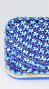 Exquisite rhinestone detail of blue evening clutch bag, sparkling crystal embellishments.