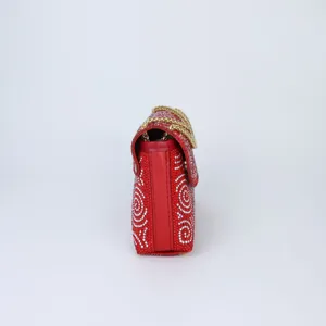 Detailed side view of a red rhinestone evening bag showing sparkly crystal pattern and chain.