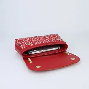 Detailed view of red rhinestone evening shoulder bag showing interior capacity with phone.
