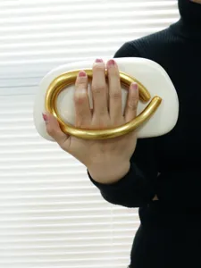 Elegant white clutch bag with sculptural gold metal handle, vintage evening handbag for women.