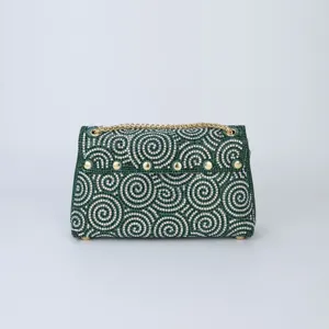 Detailed view of a stunning green rhinestone encrusted evening shoulder bag with sparkling swirl design.