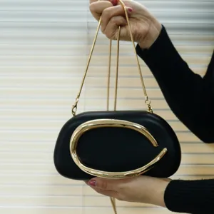Black leather evening clutch bag with gold tone metal anchor hardware and chain strap main view