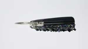 Close-up view of elegant black evening clutch bag with sparkling beads and metal ring handle.