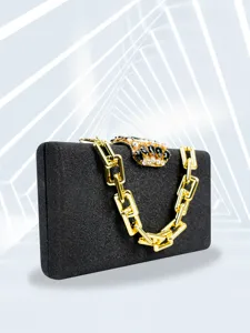 Close-up detail of luxury black evening clutch with chunky gold chain and crystal clasp.