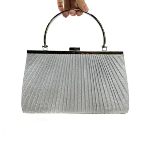 Silver evening clutch bag with metallic round handle and pleated sparkly design detail.
