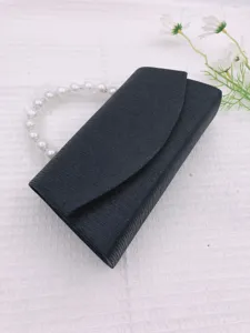 Detailed view of the elegant black evening clutch bag featuring a stylish faux pearl handle.
