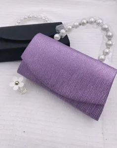 Detailed view of the elegant purple glitter evening clutch bag with gorgeous pearl handle.