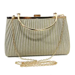 Close-up detail of shiny glitter evening clutch bag with elegant golden metal handle and chain.
