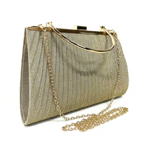 Gold glitter evening clutch bag detail, metal top handle and chain strap, elegant party accessory.