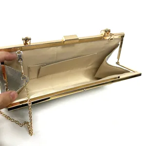 Elegant evening clutch bag interior detail showing gold metal frame, clasp and chain strap.