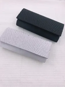 Detailed close-up view of rhinestone pleated evening clutch bags in black and silver for party.