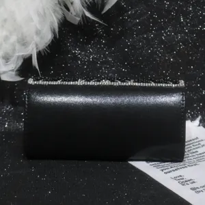 Black satin evening clutch bag detail, elegant rhinestone and beaded flap design for party use.
