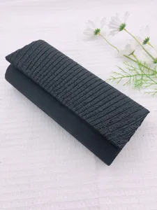 Detail view of black pleated rhinestone evening clutch bag, elegant flap design, sparkling beads.