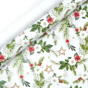 Detailed view of Christmas wrapping paper featuring watercolor rose and pine designs.