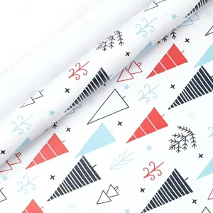 Christmas wrapping paper detail shot, red and blue tree pattern on white gift wrap roll.