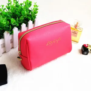 Detailed shot of the pink cross-pattern leather cosmetic pouch zipper and textured surface.