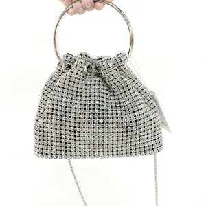 Detailed view of silver rhinestone bucket bag, metal ring handle and chain strap craftsmanship.