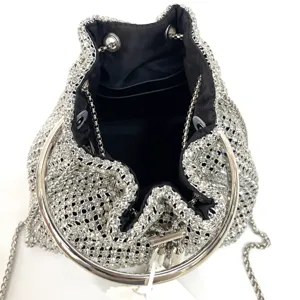 Close-up detail of luxury crystal rhinestone evening bucket bag with metal ring handle.