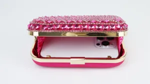 Pink rhinestone evening clutch bag with gold metal frame, elegant party purse for women detail.