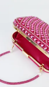 Exquisite rhinestone evening clutch bag detail, sparkling pink crystals and gold metal trim.