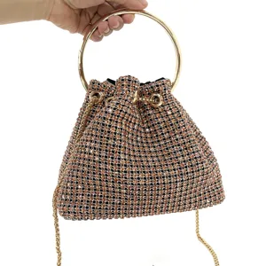 Close-up detail of luxury rhinestone evening bag with metallic ring handle and chain strap.