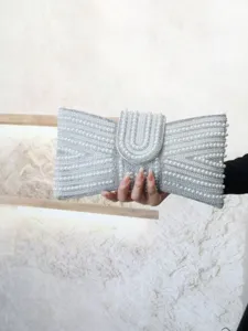 Detail view of a stunning pearl and rhinestone beaded evening clutch bag, elegant bow design.