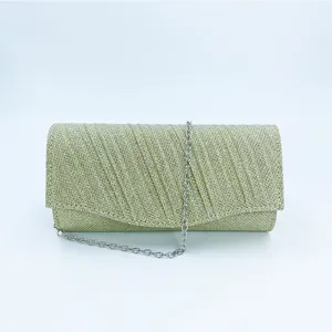 Close-up detail of the gold glitter evening clutch bag, featuring fine pleated texture.
