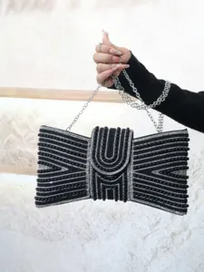 Elegant black beaded evening clutch bag detail, showcasing intricate bow pattern and chain.