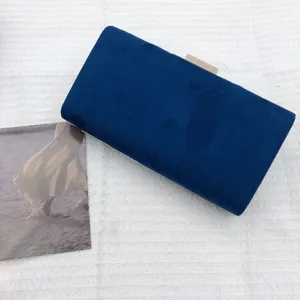 Detailed view of dark blue velvet evening clutch bag with metal clasp, elegant party accessory.