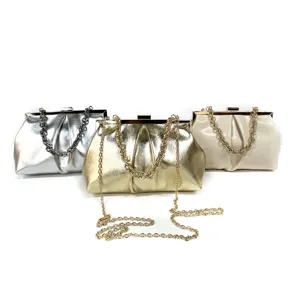 Close-up detail of metallic evening clutch bag, showing pleated texture and chain strap.