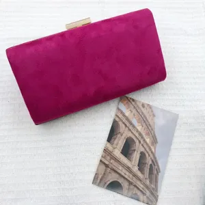 Close-up view of a magenta velvet evening clutch bag with chic gold-tone clasp closure detail.