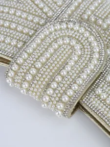Exquisite detail of women evening clutch bag adorned with pearls and shimmering rhinestones.