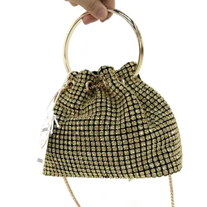 Detailed view of luxury rhinestone evening bag with gold ring handle and sparkling crystals.