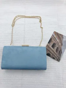 Blue suede hard case clutch bag detail view with gold chain strap and metal clasp closure.