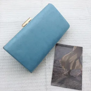 Blue suede evening clutch bag with elegant metallic clasp, perfect for parties and weddings.