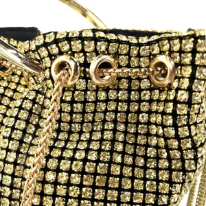 Close-up detail of luxury rhinestone evening bucket bag with sparkling crystals and gold hardware.