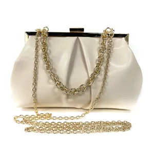 Elegant cream evening clutch bag with chic gold chain straps and metal frame closure.