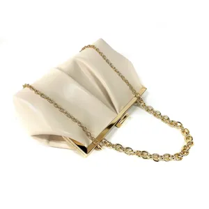 Close-up detail of a chic beige gathered clutch bag with elegant gold-tone hardware and chain.