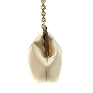Detail view of the cream white evening clutch handbag with golden metal frame and chain strap.