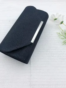 Detail view of a black glitter evening clutch bag with a sleek silver metallic bar closure.