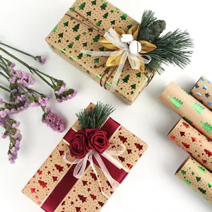 Vintage kraft wrapping paper rolls with gold stamping Christmas tree and star patterns for gifts.