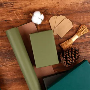 Vintage cadeaupapier set met groene rollen, kraft labels, touw en natuurlijk dennenappeldecor.