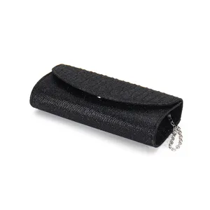Black glitter evening clutch bag detail view, shimmering texture and silver chain strap.