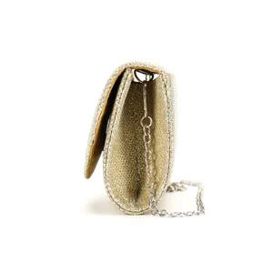 Side detail view of a elegant gold glitter evening clutch bag with a silver chain strap.