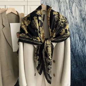Detailed view of luxury black silk scarf with ornate gold baroque print design for women.