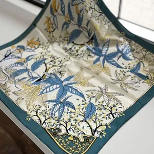 Detailed view of luxury botanical silk square scarf with elegant floral print and green border.