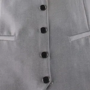 Grey suit waistcoat detail closeup, formal business vest with black buttons and pockets.
