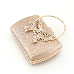 Exquisite detail of gold sequin evening bag featuring sparkling rhinestone bow and chic metal ring.