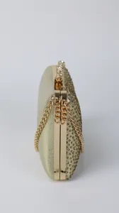 Gold rhinestone evening clutch detail, luxury party handbag with metal chain and crystal embellishments.